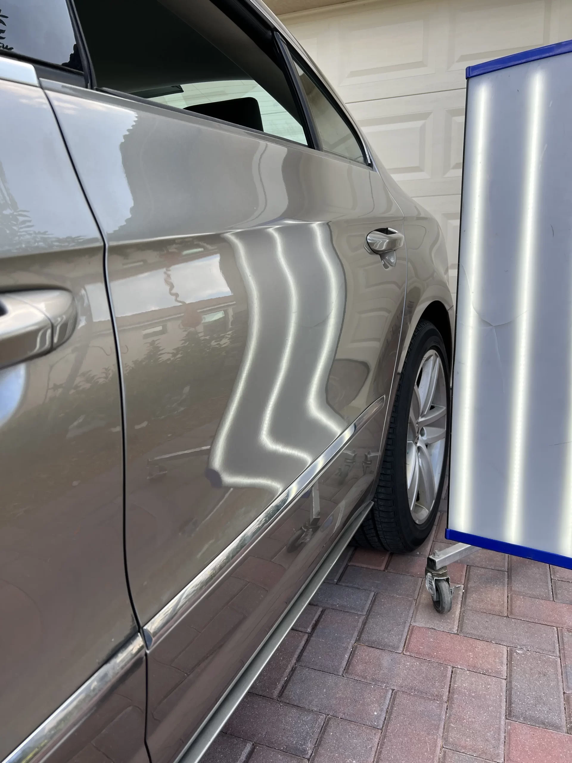 The right side of a grey car reflective door panel after being repaired.