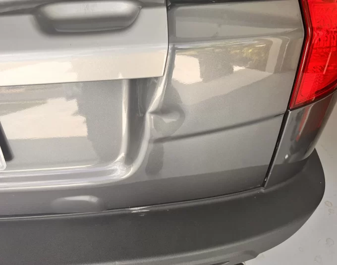 A close-up of the rear bumper of a grey vehicle.